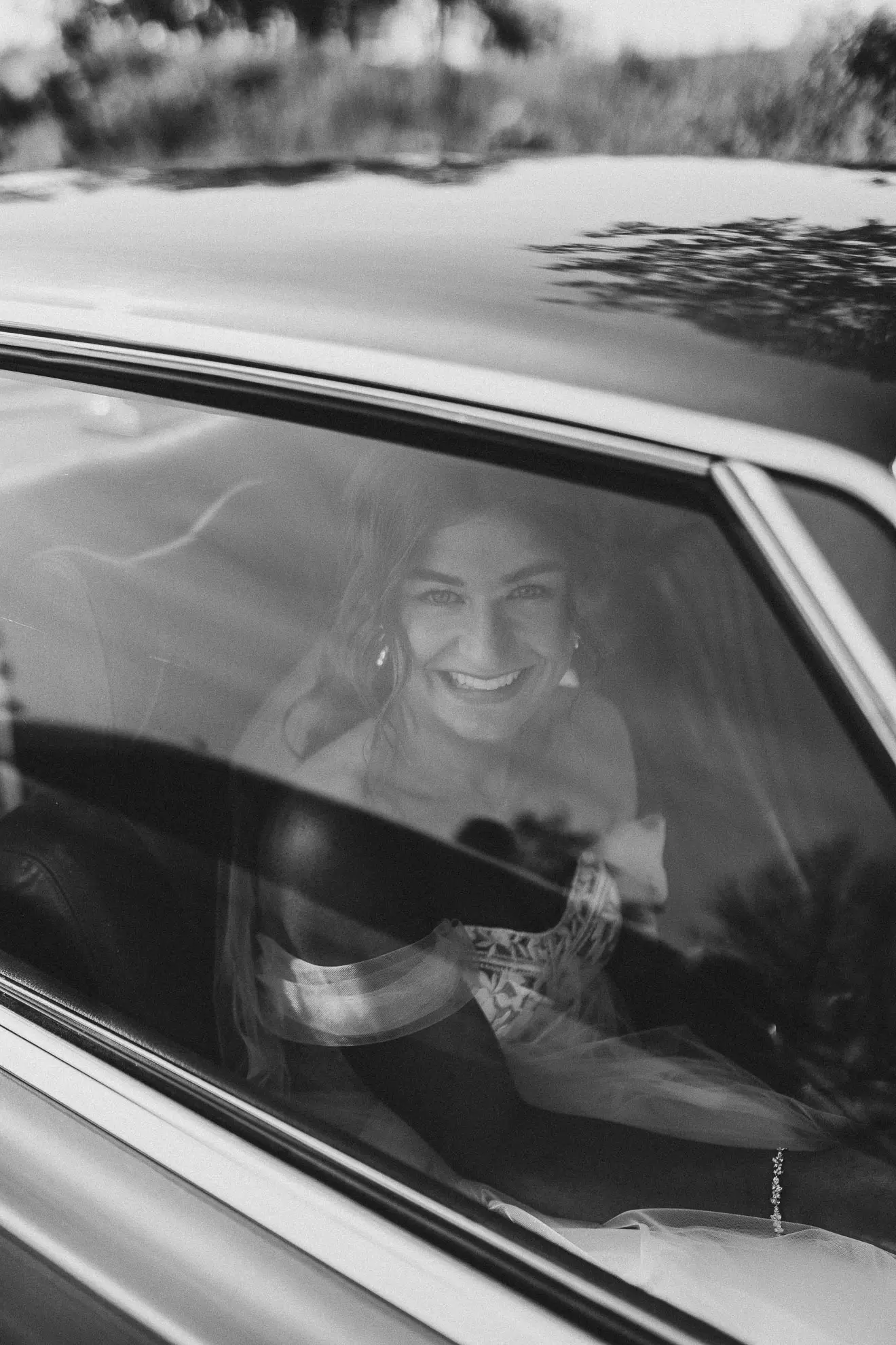 Die Hochzeitsfotografin Katja Stumbeck aus Straubing hat ein Schwarz-Weiss-Foto von einer Braut gemacht, die in einem Auto sitzt und durch die Fensterscheibe guckt