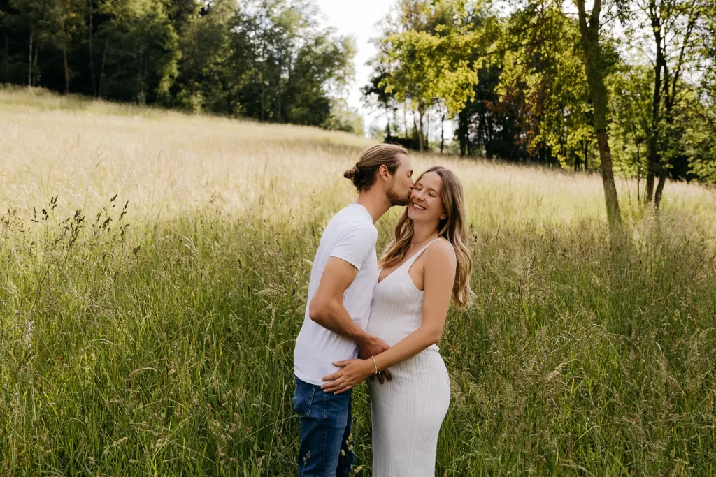 Ein Pärchen beim Babybauchshooting auf einer Wiese