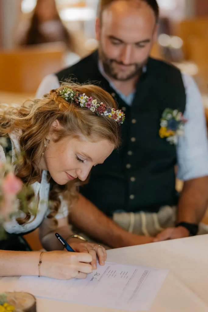 Braut unterschreibt während standesamtlicher trauung