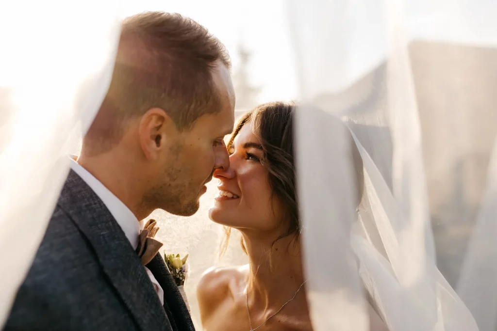 Brautpaar unterm Brautschleier beim Fotoshooting fotografiert von Hochzeitsfotografin Katja Stumbeck
