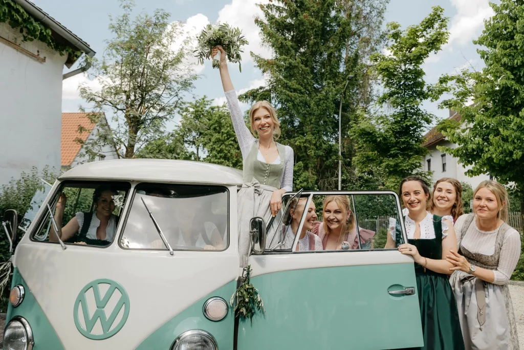 Braut mit ihren Freundinnen neben einem mintfarbenen Bully