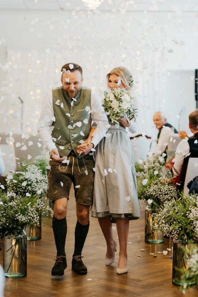 Brautpaar unter Konfetti-Regen nach der Trauung