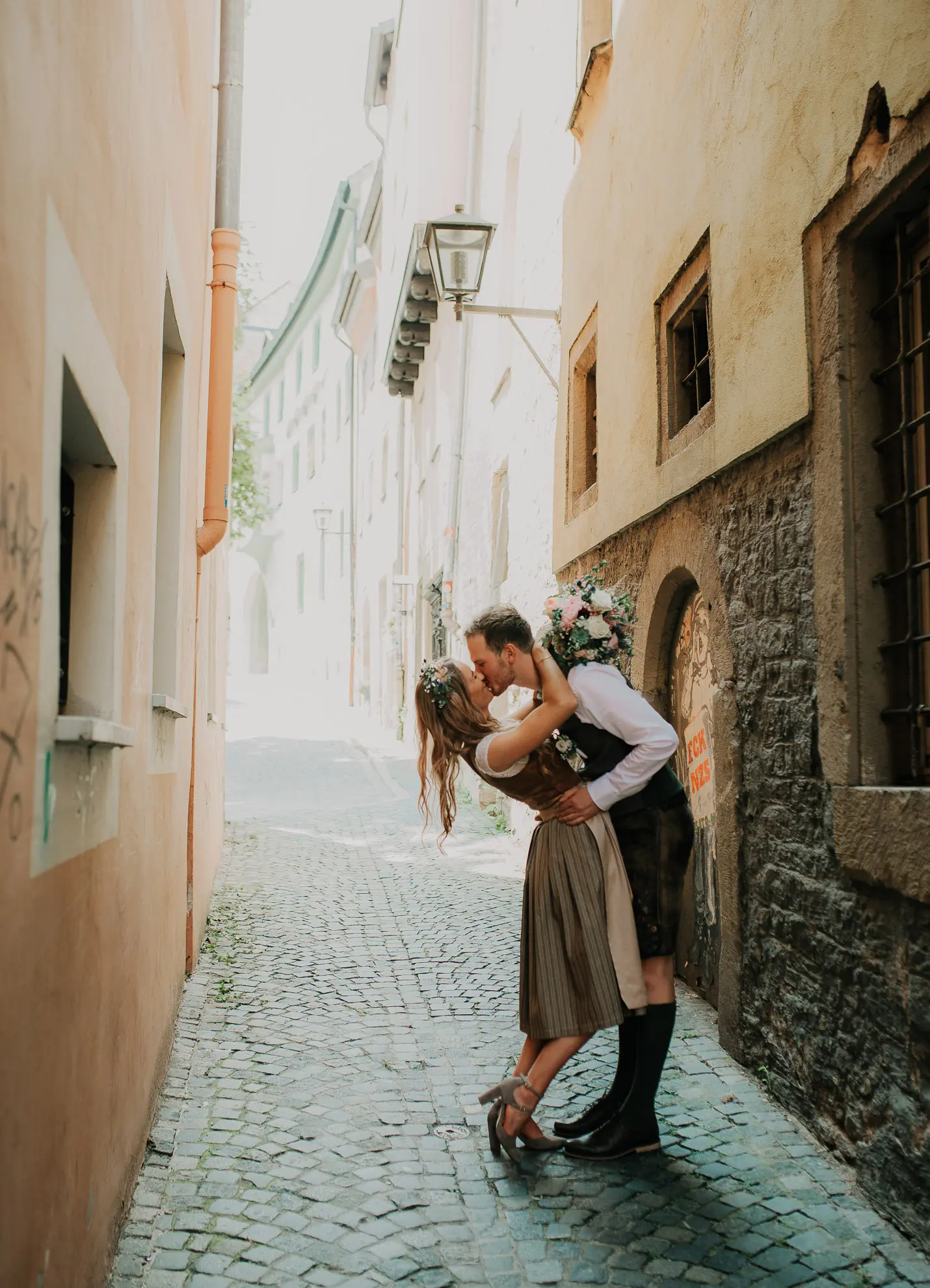 Ein junges Brautpaar aus Straubing küsst sich in den engen Gassen der Stadt und Hochzeitsfotografin Katja Stumbeck hält das fest